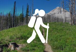 White image of female hiker with mountain and burnt forest in the background